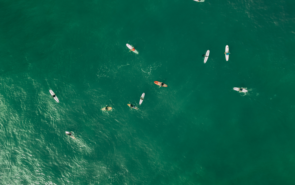 Aerial view of surfers floating on turquoise waters near Nosara, embodying the vitality and active lifestyle of the Blue Zone.